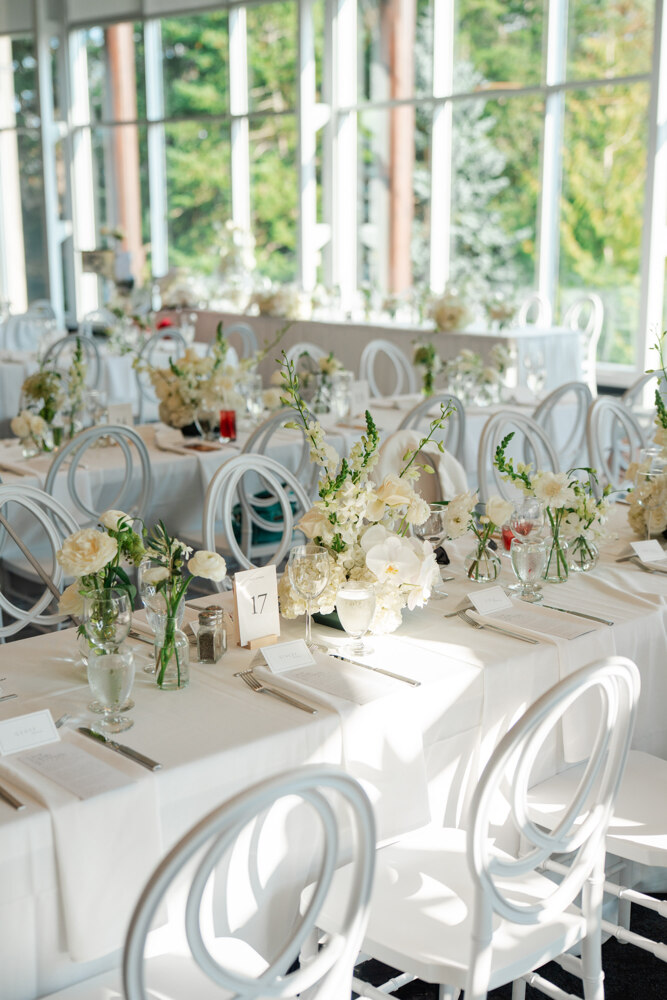 Reception head table styled with white floral arrangements