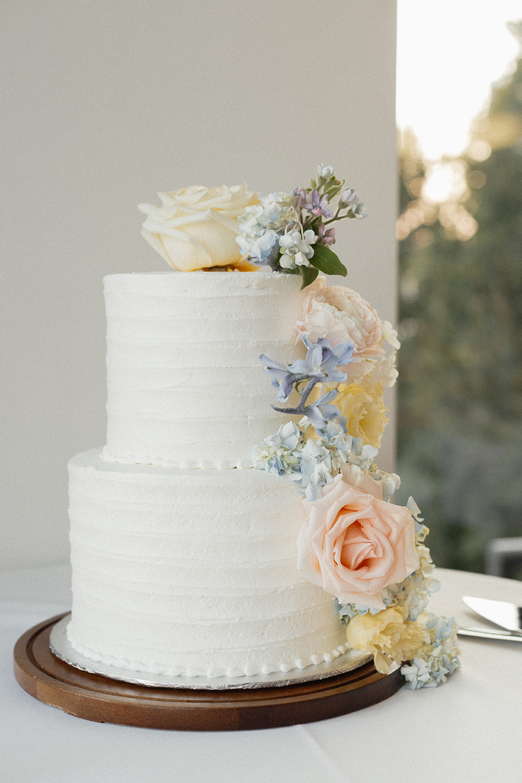Two-tier wedding cake trailing blush and blue florals
